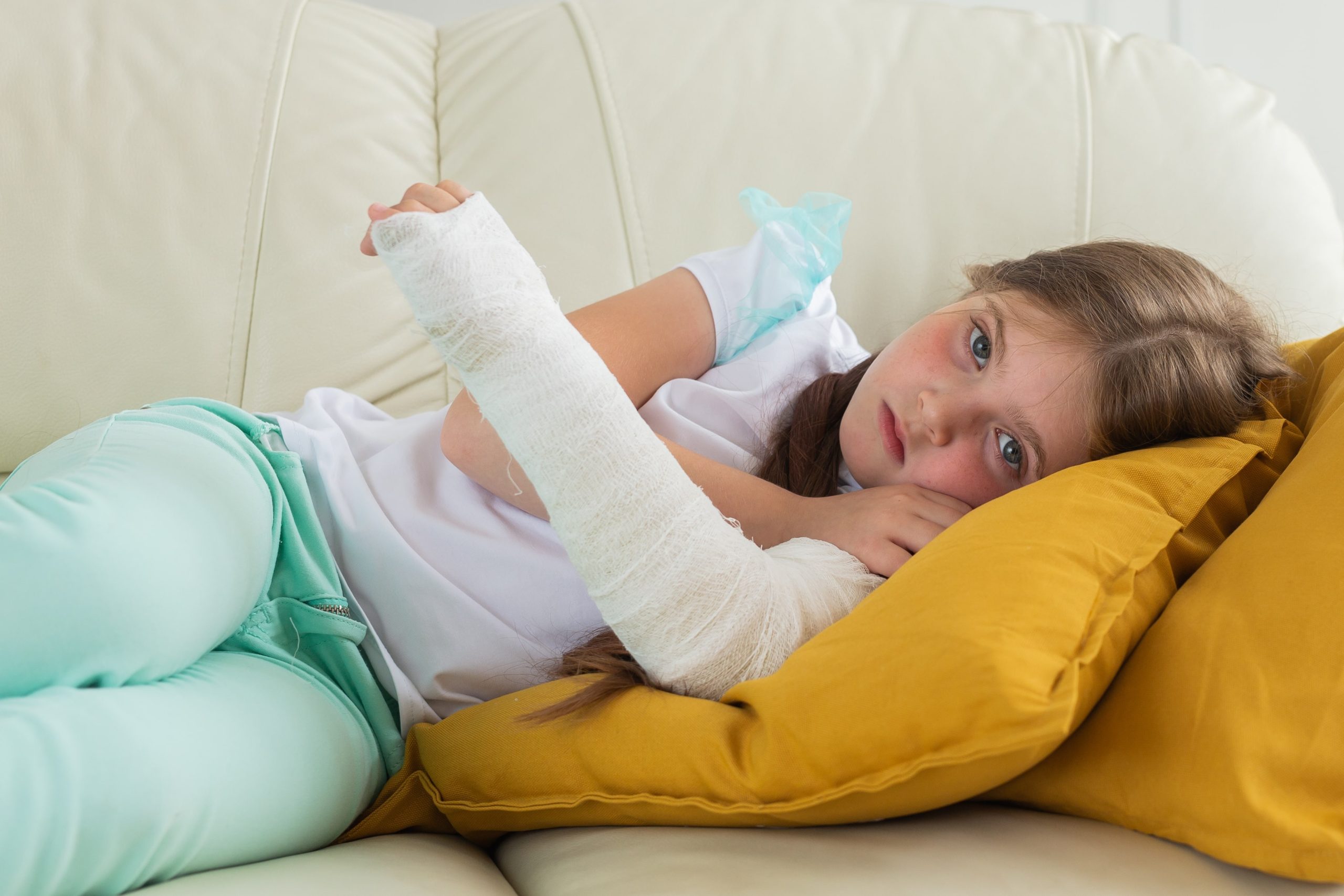 child-with-cast-broken-wrist-arm-lying-couch-recovery-disease-concept-min